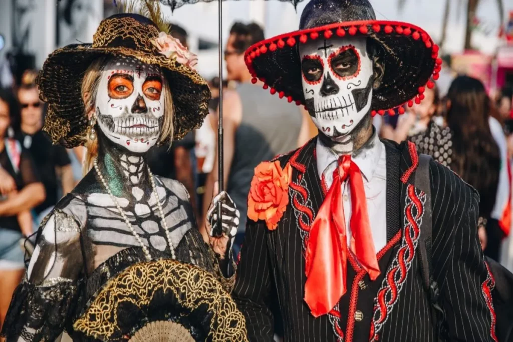 Dia dos Mortos, casal de 'Catrinas' com maquiagem de caveira, roupas elegantes e chapéus.