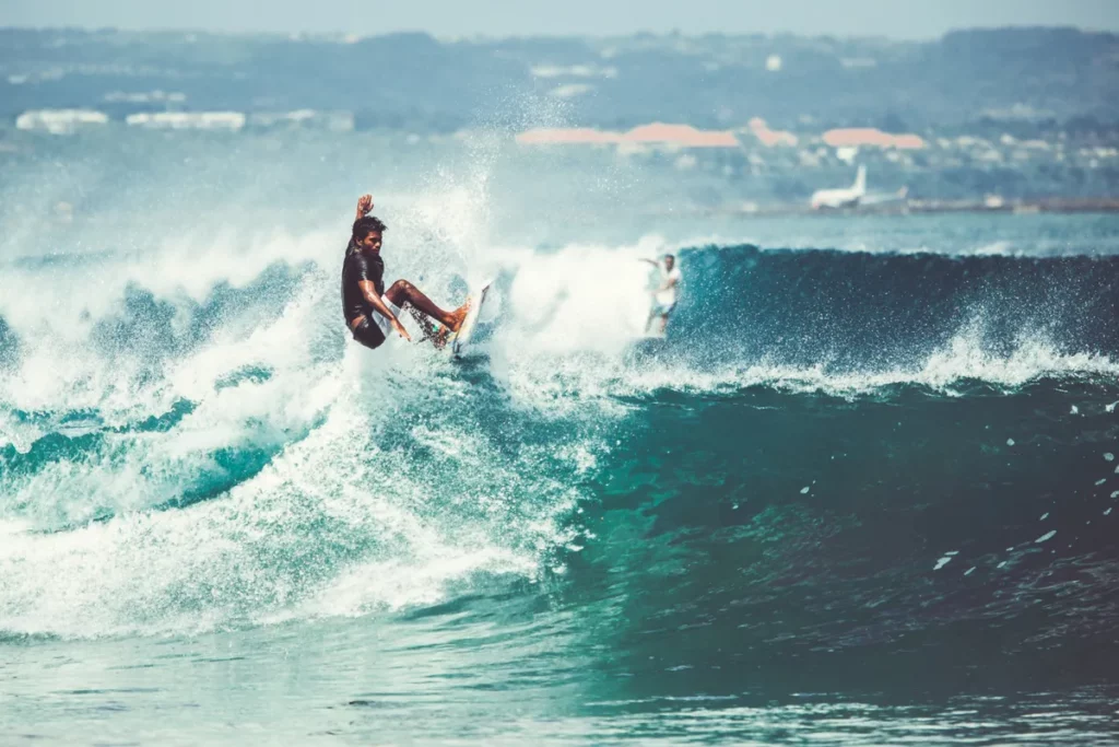 Surfista em uma prancha pegando uma onda, praticando surf no mar.