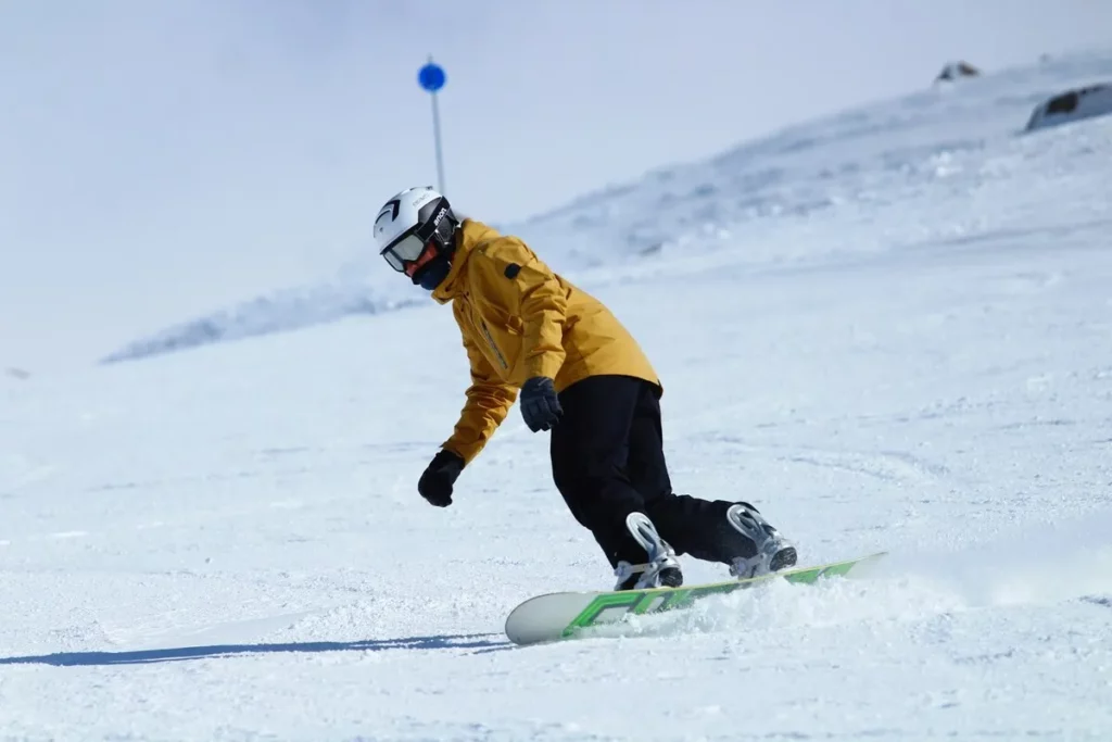 Snowboarder descendo uma montanha de neve em Bariloche, com a palavra-chave "coisas legais para fazer em Bariloche" para amantes de esportes de inverno.