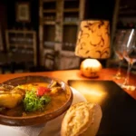 Prato de guisado de carne em um restaurante aconchegante, representando a comida típica da Bolívia.