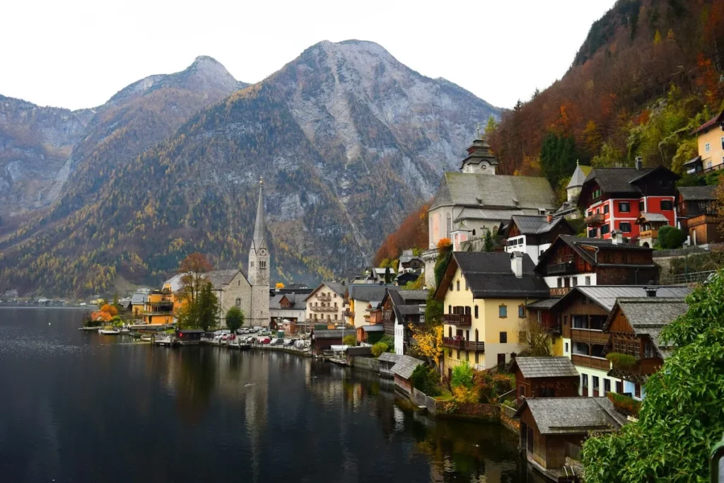 Dicas de viagem para a pitoresca vila de Hallstatt, na Áustria, com casas nas montanhas e à beira do lago.