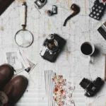 Dicas de viagem com mapa, câmera fotográfica e acessórios de aventura.