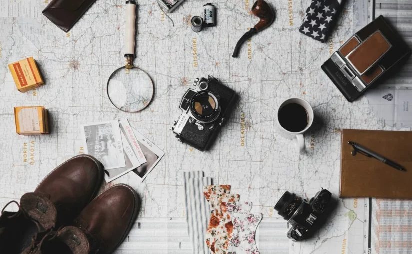 Dicas de viagem com mapa, câmera fotográfica e acessórios de aventura.