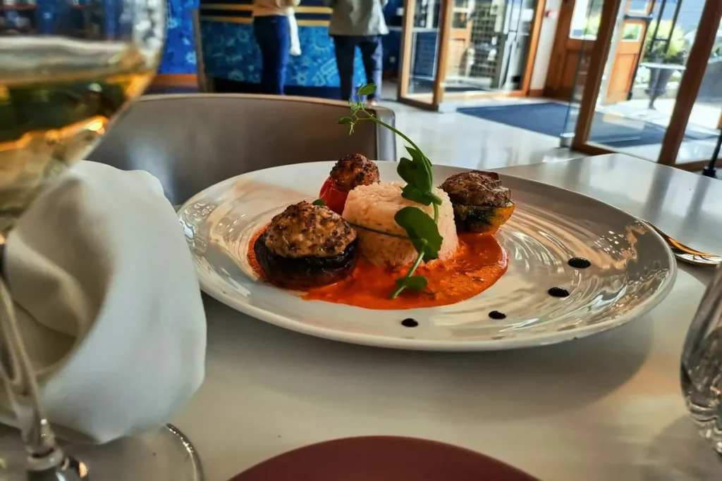 Prato sofisticado com arroz e vegetais recheados em um restaurante, focado na alta gastronomia.
