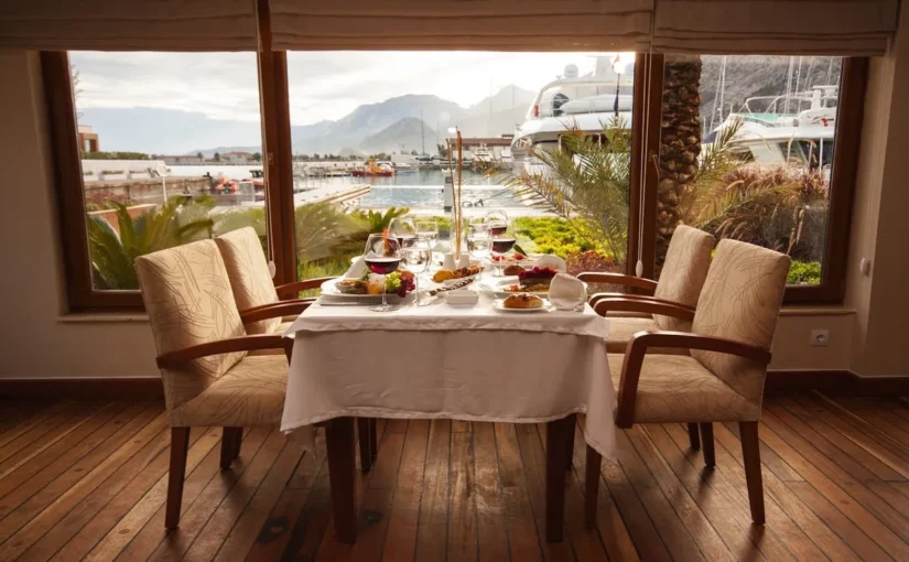 Mesa de restaurante posta com vista para o mar, simbolizando a experiência de gastronomia de luxo.