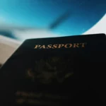 Viagem barata internacional: Passaporte com a palavra "PASSPORT" escrita em dourado.