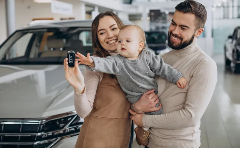 Família feliz com um bebê posando com a chave de um carro novo, representando a experiência de alugar carro.