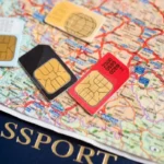 Vários chips de celular coloridos sobre um mapa de viagem e um passaporte, simbolizando a conectividade em viagens internacionais.