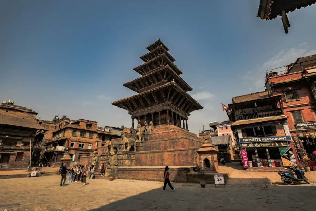 Templo Nyatapola em Bhaktapur, Nepal, com turistas explorando a praça histórica, um dos melhores lugares para viajar sozinho.
