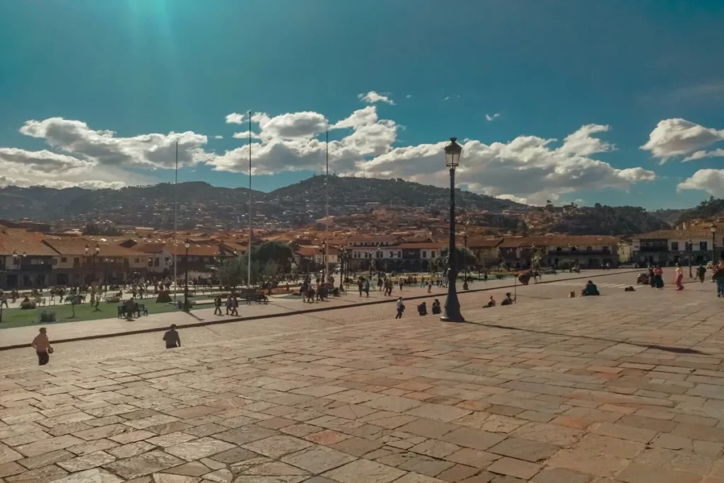 Vista da Plaza de Armas em Cusco, Peru, com turistas caminhando e montanhas ao fundo, um dos melhores lugares para viajar sozinho.