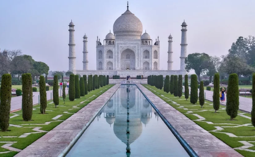 Vista frontal do Taj Mahal em Agra, Índia, com jardim e espelho d’água, destino ideal para viagem solo cultural e espiritual.