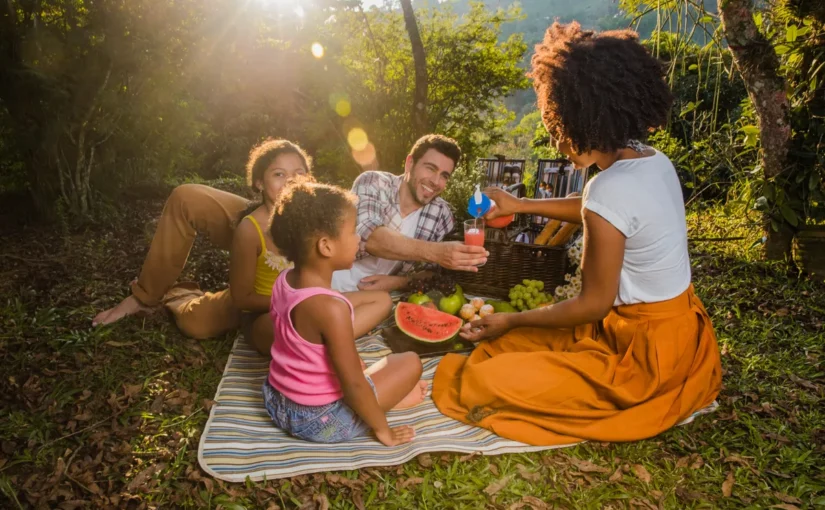 Família feliz desfrutando de um dos muitos piqueniques ensolarados no campo.
