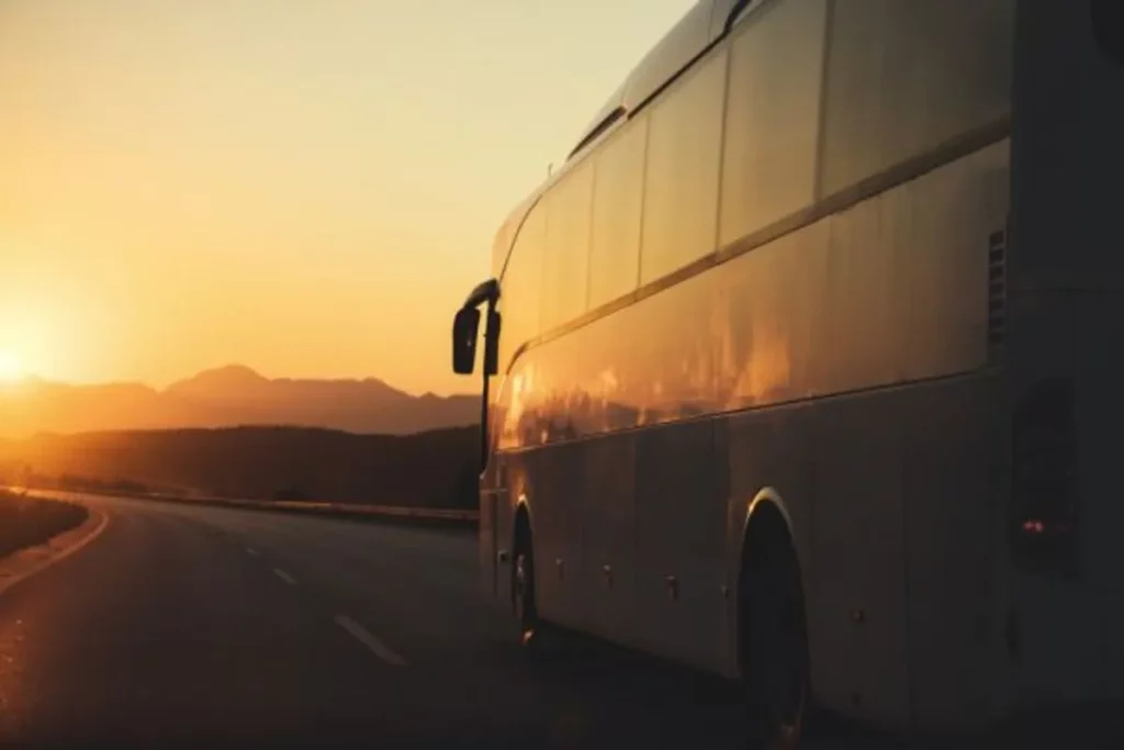Ônibus de viagem em estrada durante o pôr do sol.