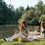 Parques nacionais Brasil: 5 destinos ideais com trilhas seguras para crianças Família fazendo piquenique em área verde com lago em um dos parques nacionais do Brasil