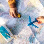 Pessoa segurando um avião de brinquedo em cima de um mapa