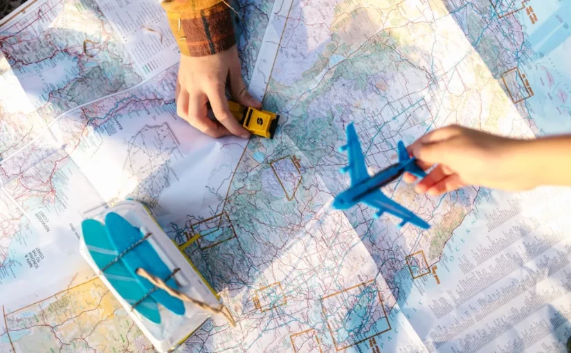 Pessoa segurando um avião de brinquedo em cima de um mapa