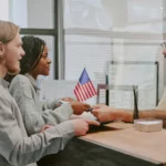 casal entregando passaporte para agente de imigração em balcão de aeroporto